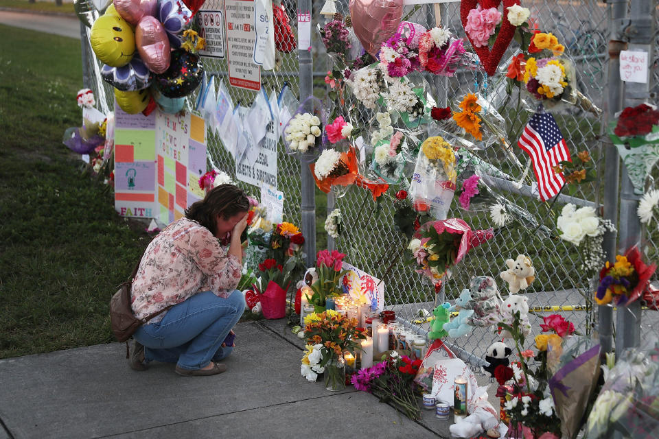 A mourner observes flowers left at the scene of the Florida high school massacre last week. (AFP/Getty)