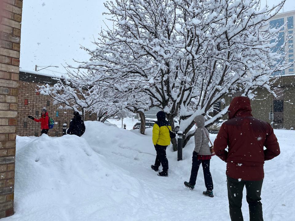 Several people braving the cold in snow gear and walking inside a building