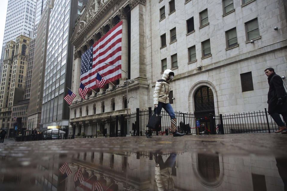 FILE - In this Thursday, March 19, 2020 file photo, a pedestrian wearing a face mask and gloves walks past the New York Stock Exchange in New York. On March 23, 2020, the S&P 500 fell 2.9%. In all, the index dropped nearly 34% in about a month, wiping out three years’ worth of gains for the market. (AP Photo/Kevin Hagen)