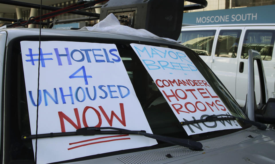 FILE - In this April 3, 2020, file photo, activists protest from vehicles outside Moscone Center, asking San Francisco Mayor London Breed to house homeless people using vacant hotels in San Francisco. San Francisco's mayor reported Friday, April 10, 2020, that 70 people at the city's largest homeless shelter have tested positive for COVID-19, infuriating advocates of the homeless who have been pushing the city for weeks to get people out of crowded shelters and into individual hotel rooms. (AP Photo/Ben Margot, File)