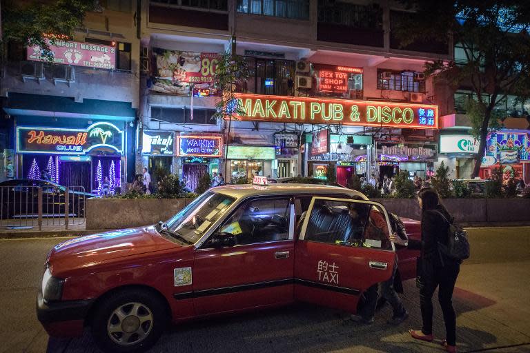 Two women board a taxi near bars and restaurants in Hong Kong's Wanchai district on November 3, 2014