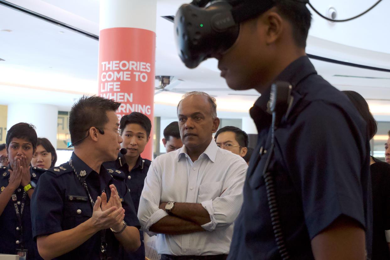 Law and Home Affairs Minister K Shanmugam (in white) observing a police virtual reality training simulator in action during the Police Workplan Seminar held on Thursday (3 May). (PHOTO: Dhany Osman / Yahoo News Singapore)