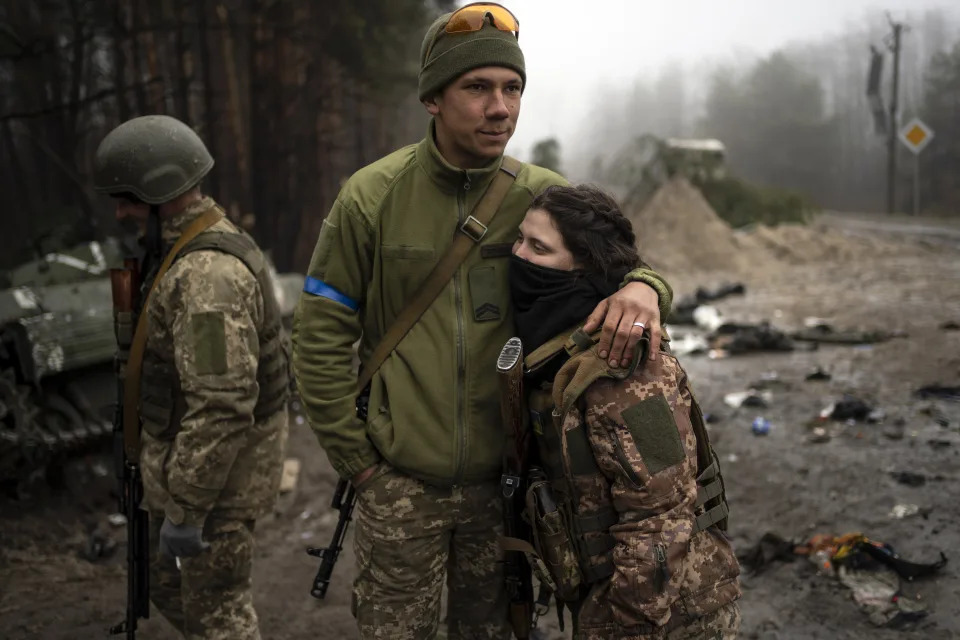 Ukrainian army soldiers, Igor, 23, embraces his wife Dasha, 22, after conducting a military sweep to search for possible remnants of Russian troops after their withdrawal from villages on the outskirts of Kyiv, Ukraine, Friday, April 1, 2022. (AP Photo/Rodrigo Abd)