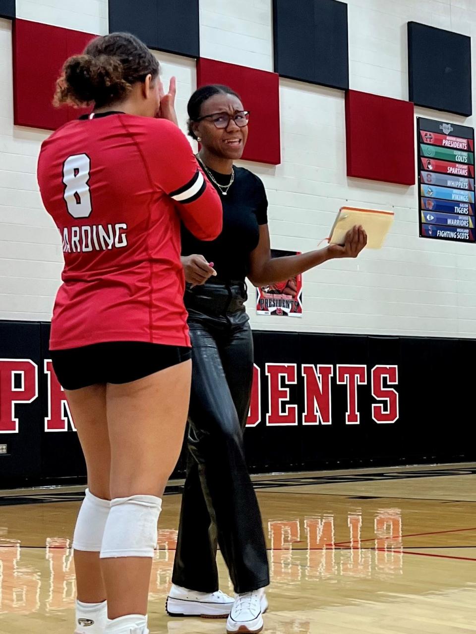 Marion Harding volleyball coach Olivia Davis talks to Nyla Sharp-Holmes during a home match with Pleasant in the fall.