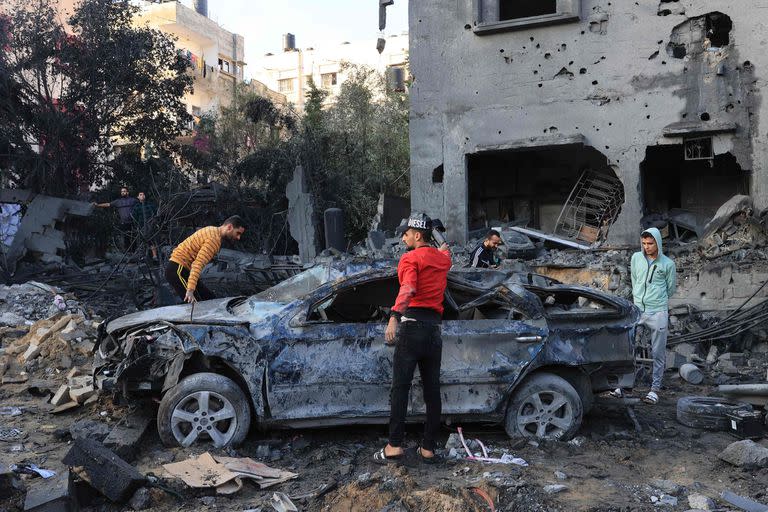 Palestinos inspeccionan los escombros de un edificio