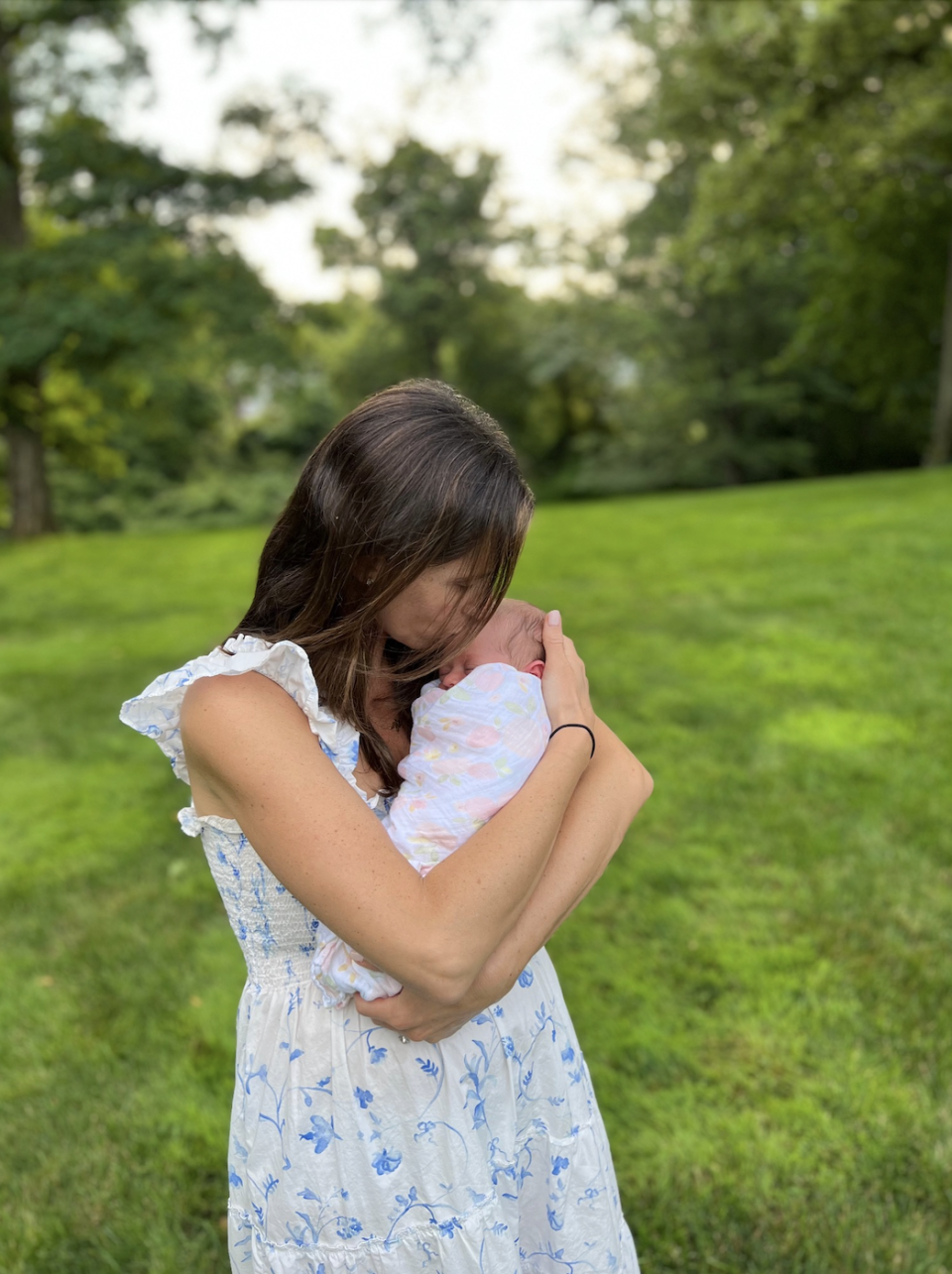 Hannah holding her newborn baby outside