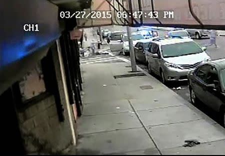 Police officers (top L) fire their weapons at a man fleeing a stopped car (top R) who police identified as Angelo West, in a still image taken from surveillance video released by the Suffolk County District Attorney's Office in Boston, Massachusetts. REUTERS/Suffolk County District Attorney's Office/Handout