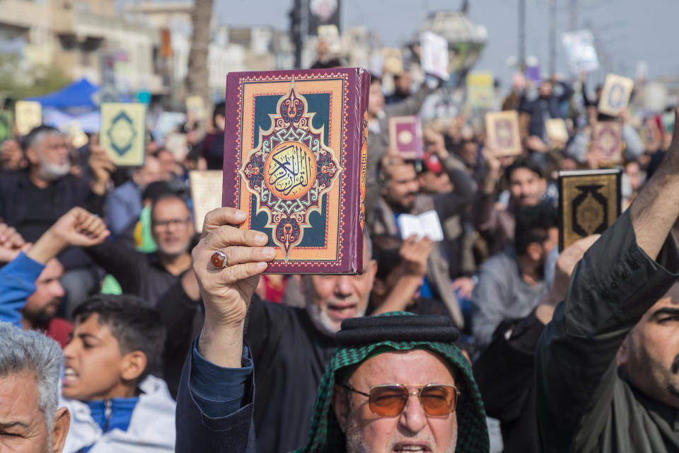 Followers of the Shiite cleric Muqtada al-Sadr raise the Quran, the Muslim holy book, in response to the burning of a copy of the Quran in Sweden, during open-air Friday prayers in Baghdad, Iraq, Friday, Jan. 27, 2023. (AP Photo/Hadi Mizban)