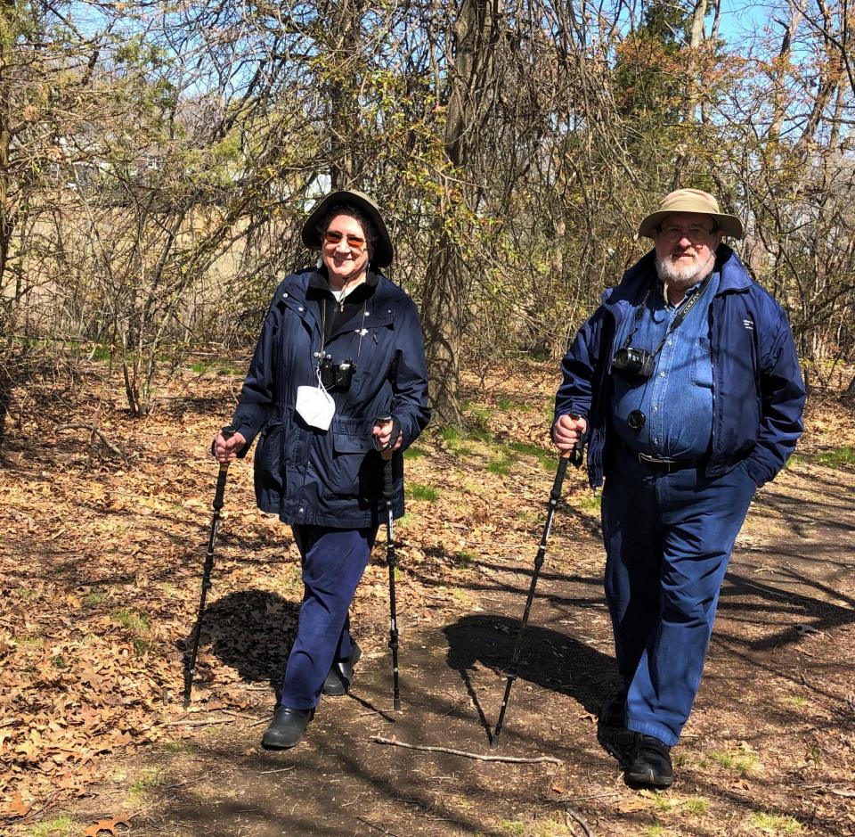 Ginger Grassa, left, and Andy Richardson, right, of Braintree, find walking poles are good companions as they hike in Quincy with the Environmental Treasures program Saturday, April 23, 2022.