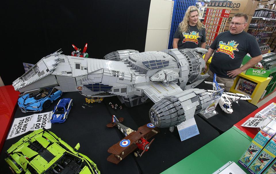 Troy Cefaratti, owner of Sir Troy’s Toy Kingdom, and Heather Marks, vice president, talk about the spaceship Serenity, from the show “Firefly,” displayed in the store. The model was built  by Adrian Drake, of Westlake, who used 75,000 Lego bricks.