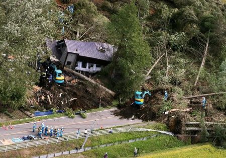 Police officers and rescue workers search for survivors from a building damaged by a landslide caused by a powerful earthquake in Atsuma town in Japan's northern island of Hokkaido, Japan, in this photo taken by Kyodo September 6, 2018. Mandatory credit Kyodo/via REUTERS