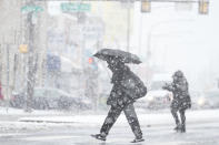 People cross a street during a winter snow storm in Philadelphia, Tuesday, Feb. 13, 2024. (AP Photo/Matt Rourke)