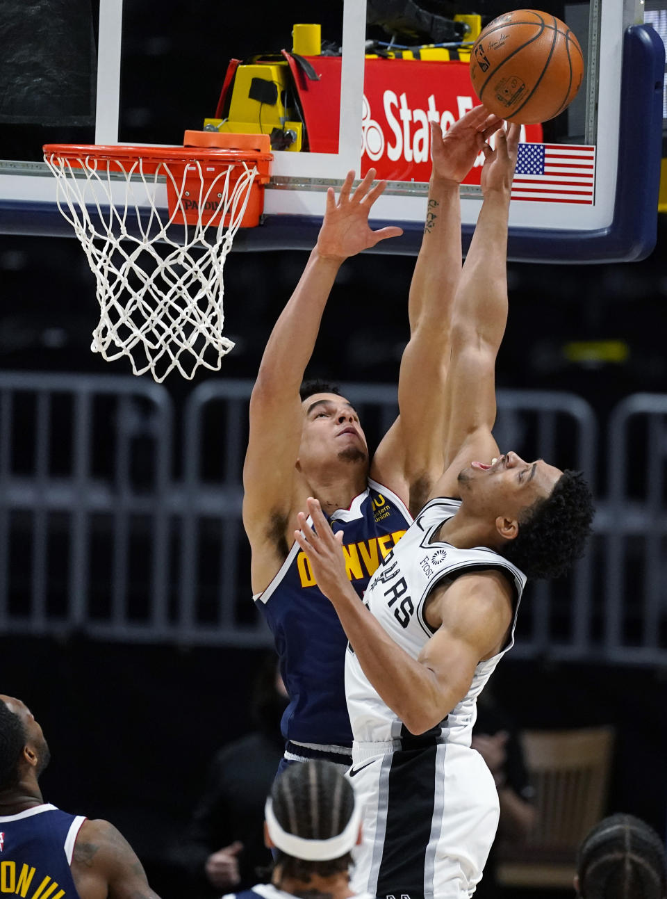 Denver Nuggets forward Michael Porter Jr., left, blocks a last-second shot by San Antonio Spurs forward Keldon Johnson in the second half of an NBA basketball game Friday, April 9, 2021, in Denver. (AP Photo/David Zalubowski)