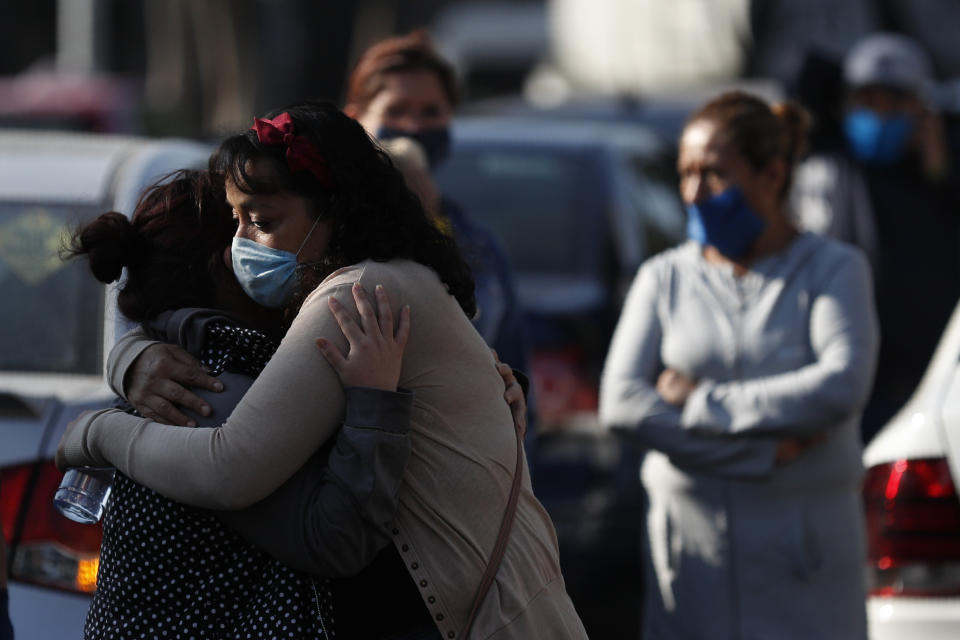 Familiares de Gabriel Martínez Gutiérrez, de 38 años, que de acuerdo con personal del hospital pudo haber muerto de complicaciones de COVID-19, se abrazan el martes 5 de mayo de 2020 afuera del crematorio San Nicolás Tolentino en Iztapalapa, en la Ciudad de México. (AP Foto/Rebecca Blackwell)