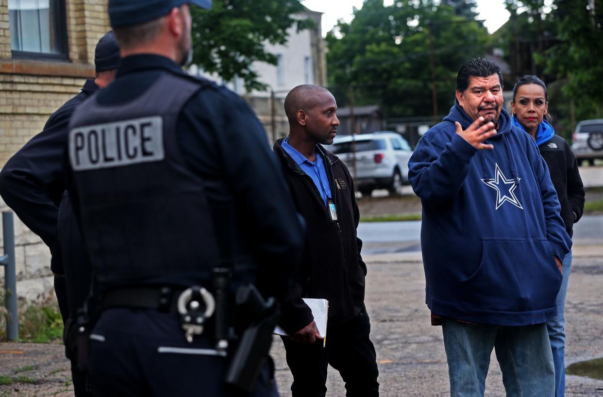 Pastor Marty Calderon (second from right) of God Touch Milwaukee speaks with community leaders and Milwaukee police officers who were participating in a neighborhood walk he led on the south side last month.