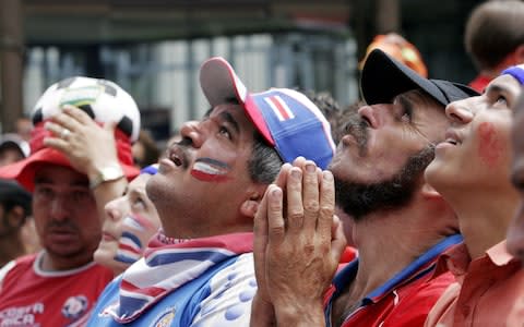 Costa Rica fans pray for their team's success - Credit: ap