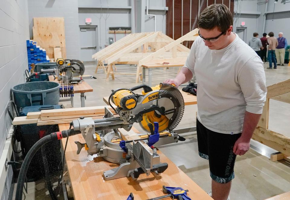 Dakota Hobson operates a compound mitre saw in during the Hillcrest High opening of the Career Technical Education Annex Thursday, Nov. 30, 2023.