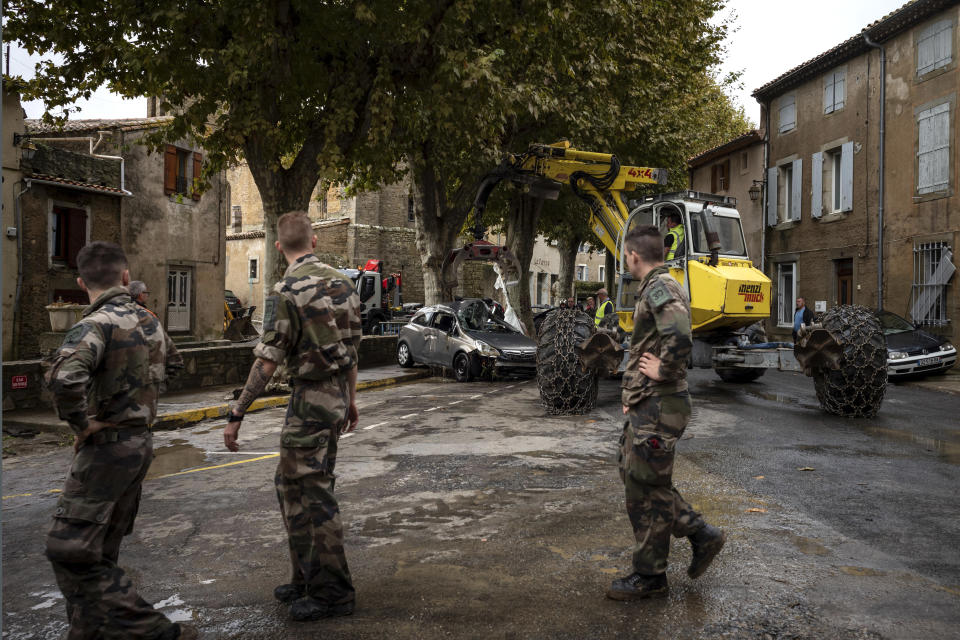 French soldiers patrol after flash floods in the town of Villegailhenc, southern France, Monday, Oct.15, 2018. Flash floods tore through towns in southwest France, turning streams into raging torrents that authorities said killed several people and seriously injured at least five others. (AP Photo/Fred Lancelot)