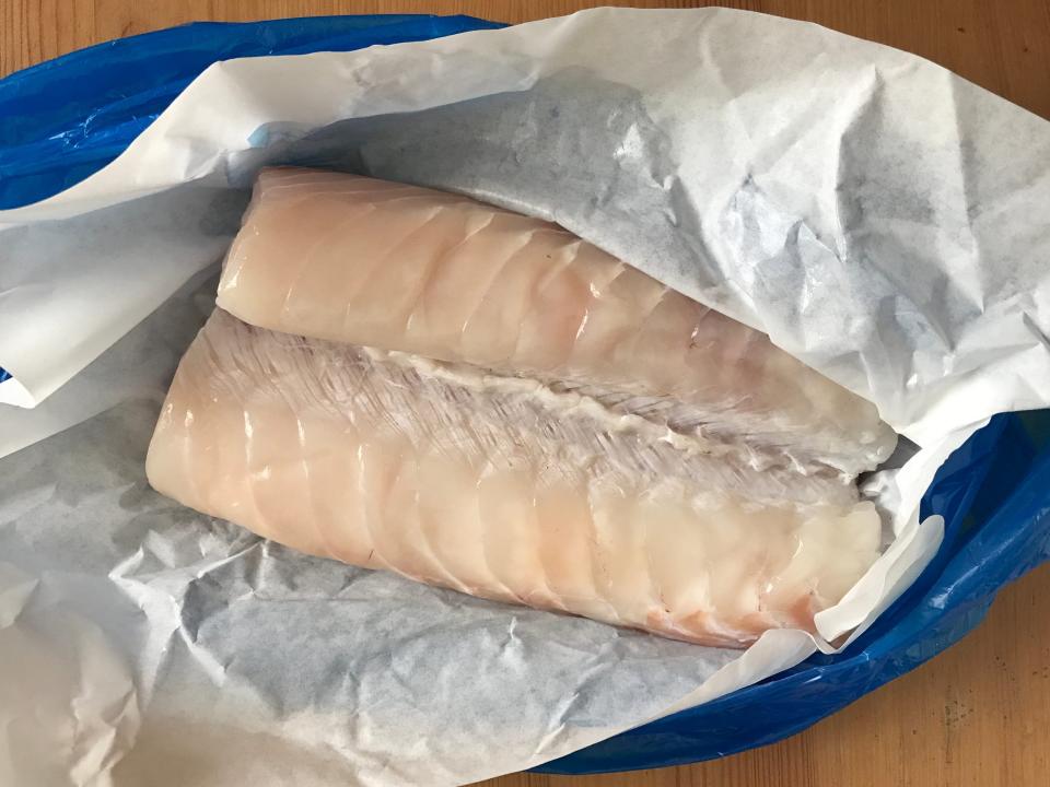 fillet of pollock in a blue plastic bag