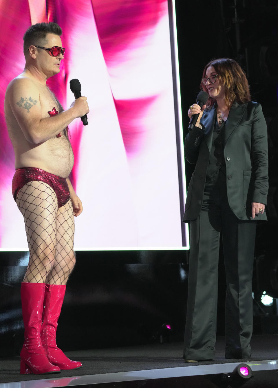 the two on stage while Nick wears boots, fishnet tights and a speedo