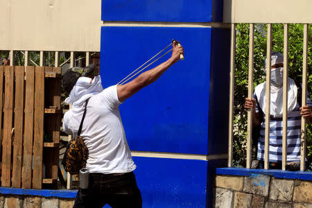 A university student uses a slingshot to throw a rock at riot police during a protest against reforms that implement changes to the pension plans of the Nicaraguan Social Security Institute (INSS) in Managua, Nicaragua April 19,2018. REUTERS/Oswaldo Rivas