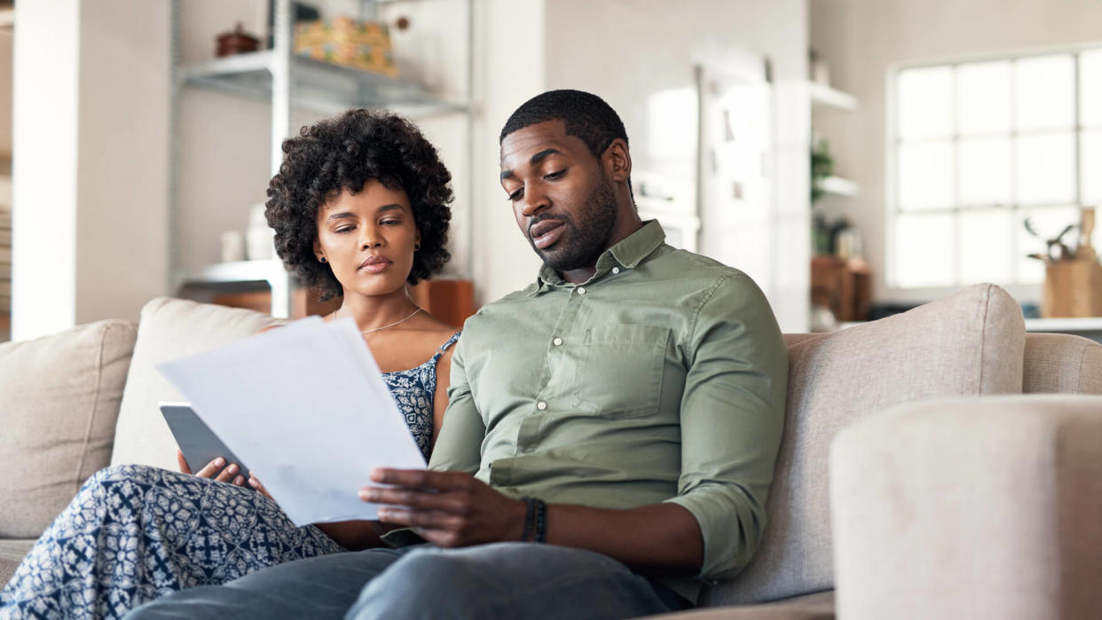 Shot of a young couple going through paperwork at home.