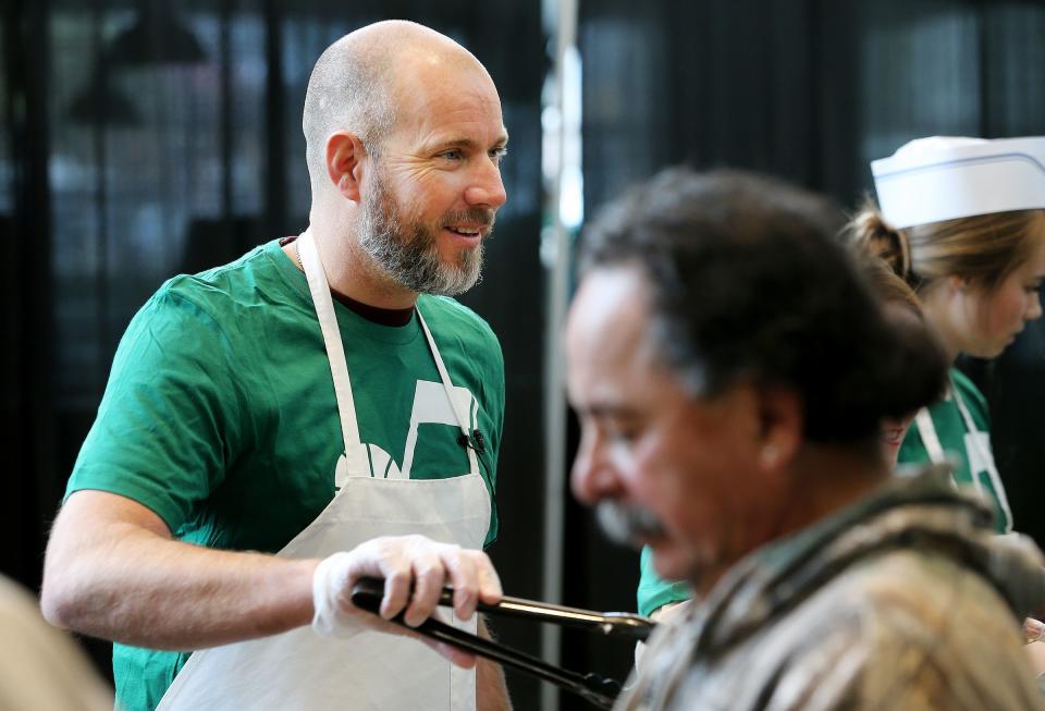 Steve Miller joins with other members of the Miller family, Larry H. Miller Sports & Entertainment employees and select Salt Lake City Stars players to serve food at the 19th annual “We Care — We Share” Thanksgiving Dinner for local homeless and low-income individuals at Vivint Arena on Monday, Nov. 20, 2017. | Scott G Winterton, Deseret News