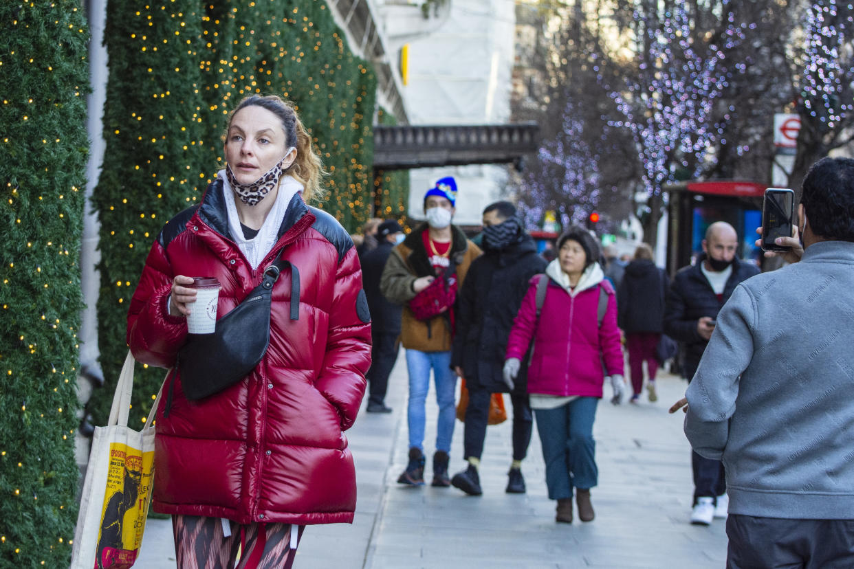 Shoppers walk past Christmas decorations in New Bond Street, London. Photo: Pietro Recchia/SOPA/LightRocket via Getty