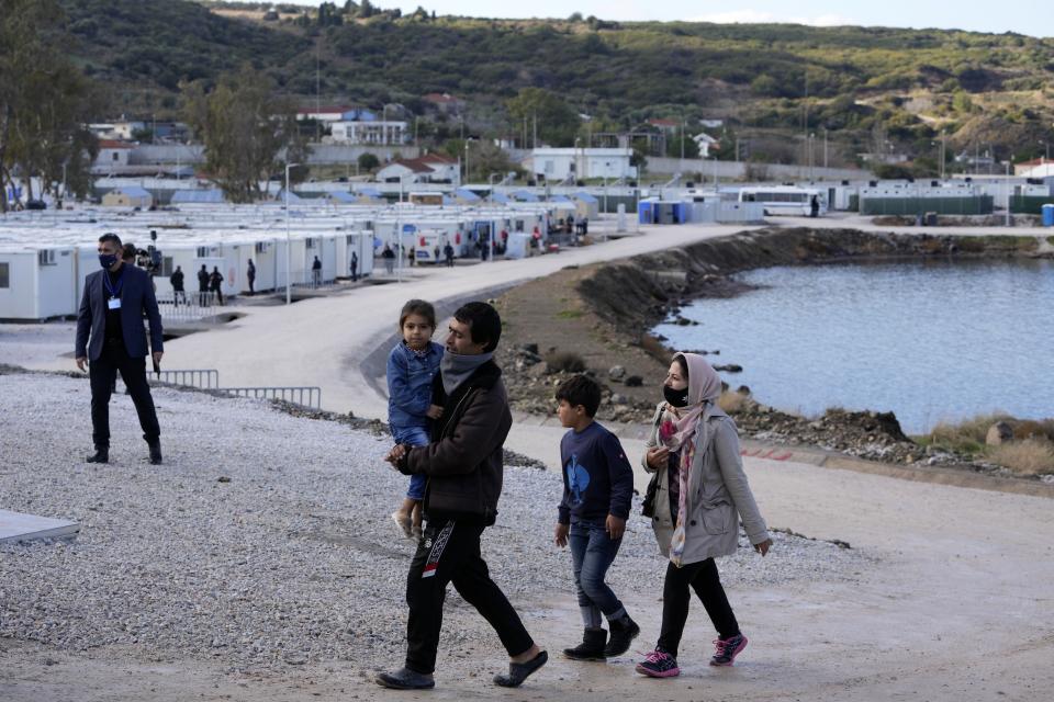 A family walks at the Karatepe refugee camp before the visit of Pope Francis, on the northeastern Aegean island of Lesbos, Greece, Sunday, Dec. 5, 2021. Pope Francis returns Sunday to Lesbos, the Greek island at the heart of a massive wave of migration into Europe to comfort its asylum-seekers, after pointedly criticizing European governments for their current handling of migrants during a visit to two hard-hit countries. (AP Photo/Alessandra Tarantino)