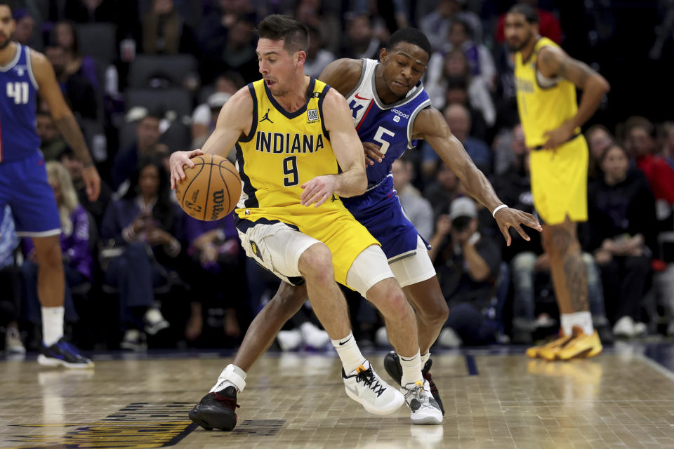 Indiana Pacers guard T.J. McConnell (9) is defended by Sacramento Kings guard De'Aaron Fox (5) during the first half of an NBA basketball game in Sacramento, Calif, Thursday, Jan. 18, 2024. (AP Photo/Jed Jacobsohn)