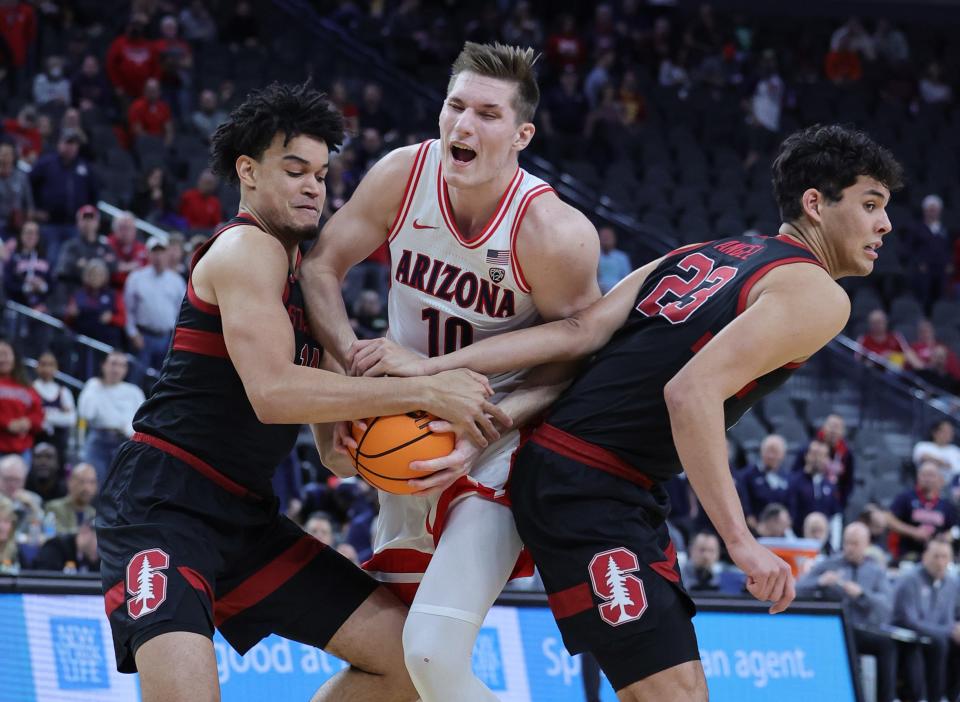Spencer Jones (14) of the Stanford Cardinal and Azuolas Tubelis (10) of the Arizona Wildcats vie for the ball as Brandon Angel (23) of the Standford Cardinal defends in the first half of a quarterfinal game of the Pac-12 basketball tournament at T-Mobile Arena on March 9, 2023, in Las Vegas, Nev.
