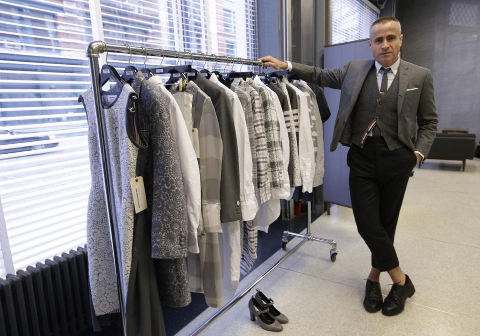 Fashion designer Thom Browne poses with clothing from his current women's wear collection in his Hudson Street store in New York, Wednesday, Feb. 20, 2013. Browne is building a business _ and what he hopes is a smart, long-lasting business at that. He's just not the overzealous, mercurial artiste. (AP Photo/Kathy Willens)