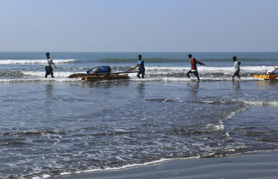 In this Jan. 16, 2017, photo, Rohingya fishermen pull their rafts made of empty plastic containers along the shallow coastline of the Bay of Bengal in Tha Pyay Taw village, Maungdaw, western Rakhine state, Myanmar. Their usual, sturdy fishing boats were outlawed three months ago when Myanmar authorities launched a sweeping and violent counter-insurgency campaign in Rakhine state, home to the long-persecuted Rohingya Muslim minority. The ban on fishing boats _ meant to prevent insurgents from entering or leaving the country by sea _ is just one small provision in the wider crackdown, in which authorities have been accused of widespread abuses. (AP Photo/Esther Htusan)