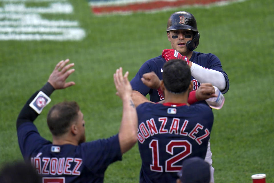 Boston Red Sox's Enrique Hernandez, top, is greeted near the dugout after hitting a solo home run off Baltimore Orioles starting pitcher Tyler Wells during the eighth inning of a baseball game, Thursday, April 8, 2021, on Opening Day in Baltimore. The Red Sox won 7-3. (AP Photo/Julio Cortez)