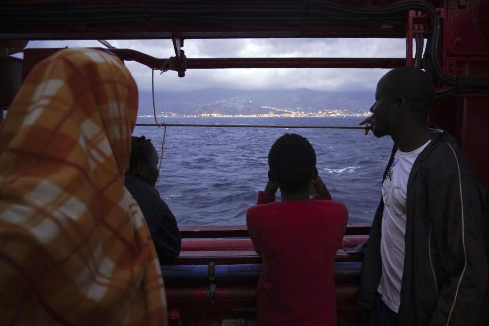 Migrants look at the Italian shoreline from aboard the Ocean Viking as it approaches the Sicilian port of Messina, southern Italy, Tuesday, Sept. 24, 2019. The Ocean Viking has docked in Sicily, Italy, to disembark 182 men, women and children rescued in the Mediterranean Sea after fleeing Libya. (AP Photo/Renata Brito)