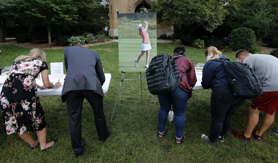 Students sign cards for the family of slain Iowa State University student Celia Barquin Arozamena during a vigil, Wednesday, Sept. 19, 2018, in Ames, Iowa. Barquin, who was the 2018 Big 12 women's golf champion and Iowa State Female Athlete of the Year, was found Monday morning in a pond at a golf course near the Iowa State campus. (AP Photo/Charlie Neibergall)