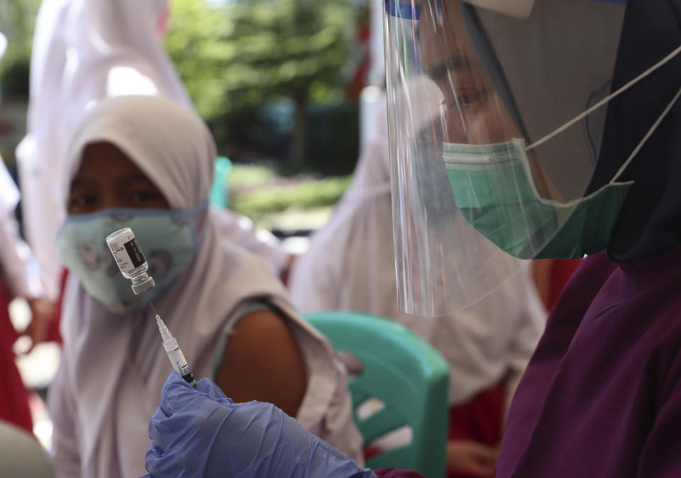 Health workers prepares to give an HPV vaccine shot to an elementary school student during a free vaccination service for school children in Jakarta,Indonesia, Tuesday, Aug. 25, 2020. (AP Photo/Achmad Ibrahim)