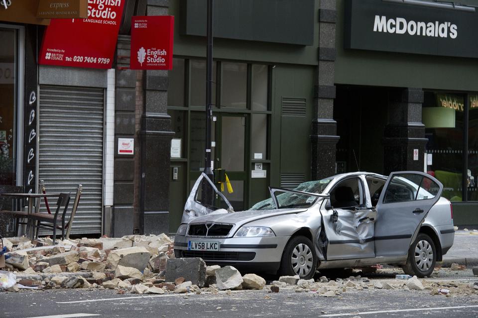 A smashed up car is seen in Kingsway opposite Holborn Tube station in central London, after a woman was killed when large chunks of masonry fell onto a Skoda Octavia vehicle she was in, London, Saturday, Feb. 15, 2014. The taxi driver was killed late Friday in central London opposite Holborn subway station during a heavy windstorm when her car was crushed by falling masonry from a building that partially collapsed, police said. She was identified as Julie Sillitoe, a 49-year-old with three sons. (AP Photo/PA, Laura Lean) UNITED KINGDOM OUT