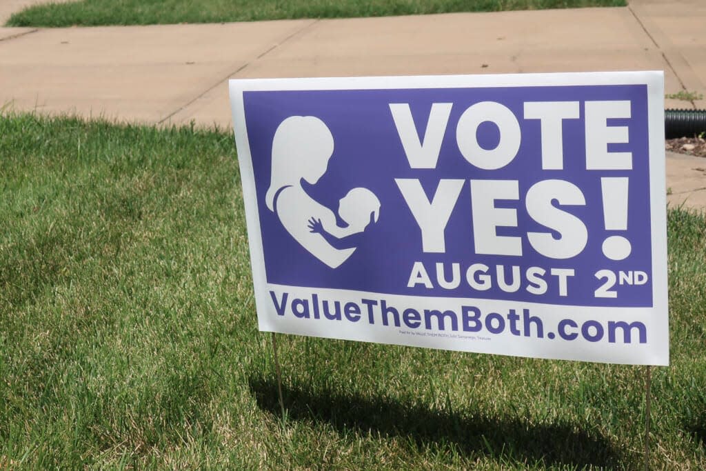 In this photo from Friday, July 8, 2022, a sign in a yard in Olathe, Kansas, promotes a proposed amendment to the Kansas Constitution to allow legislators to further restrict or ban abortion. Supporters call the measure “Value Them Both,” arguing that it protects both unborn children and the women carrying them. (AP Photo/John Hanna)