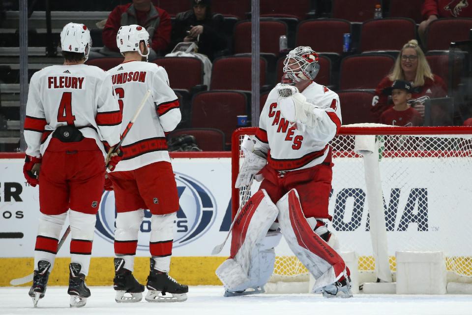 Carolina Hurricanes goaltender James Reimer, right, celebrates the team's win over the Arizona Coyotes with defensemen Haydn Fleury (4) and Joel Edmundson (6), at the end of the NHL hockey game Thursday, Feb. 6, 2020, in Glendale, Ariz. The Hurricanes won 5-3. (AP Photo/Ross D. Franklin)