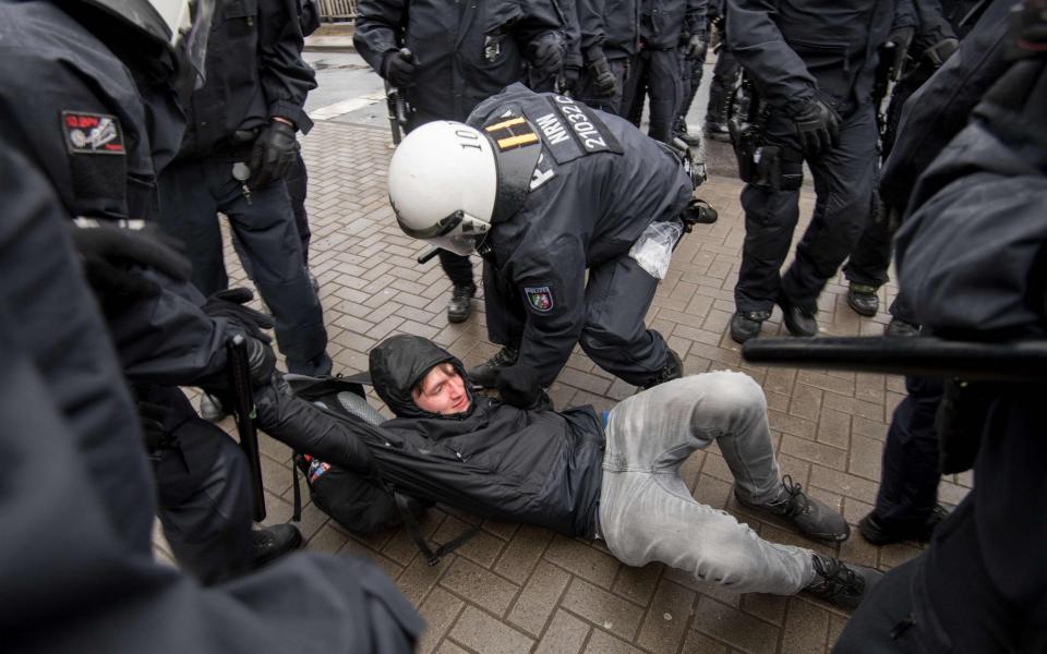 Police officers arrest a demonstrator during a protest against the party congress of Germany's right-wing populist Alternative for Germany (AfD) in Cologne - Credit: Marius Becker/AFP