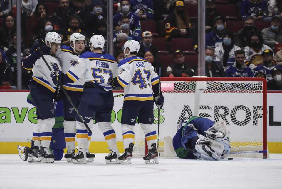 St. Louis Blues' Brayden Schenn, from left to right, Vladimir Tarasenko, of Russia, David Perron and Torey Krug celebrate Schenn's goal against Vancouver Canucks goalie Michael DiPietro during the second period of an NHL hockey game in Vancouver, British Columbia, Sunday, Jan. 23, 2022. (Darryl Dyck/The Canadian Press via AP)