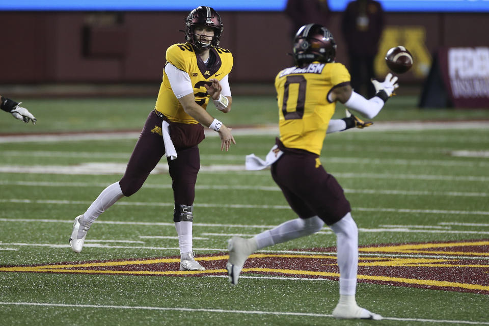 Minnesota quarterback Tanner Morgan (2) passes the ball to wide receiver Rashod Bateman (0) during the first half of the team's NCAA college football game against Purdue, Friday, Nov. 20, 2020, in Minneapolis. Minnesota won 34-31. (AP Photo/Stacy Bengs)