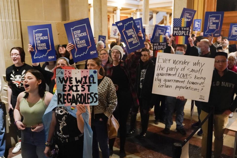 FILE - Protesters stand outside of the Senate chamber at the Indiana Statehouse, Wednesday, Feb. 22, 2023, in Indianapolis. Indiana Republican state Senators voted Tuesday, Feb. 28, to advance a ban on all gender-affirming care for those under 18, the latest in this year's conservative movement by states aiming to limit the rights of transgender youth. (AP Photo/Darron Cummings, File)