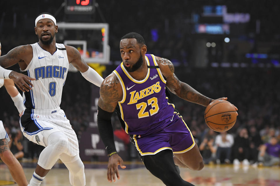 LeBron James (derecha) de los Lakers de Los Ángeles se acerca a la canasta mientras Terrence Ross del Magic de Orlando defiende durante la primera mitad de su juego NBA el miércoles 15 de enero de 2020, en Los Ángeles. (AP Foto/Mark J. Terrill)