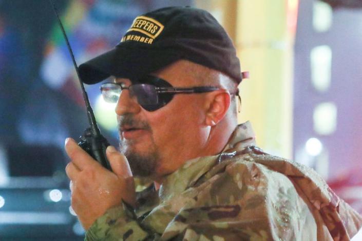 FILE PHOTO: Stewart Rhodes of the Oath Keepers uses a radio as he departs a Trump rally in Minneapolis