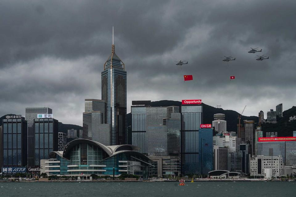 2022年7月1日，懸掛着中國國旗及香港特區區旗的直升機飛過維港上空。