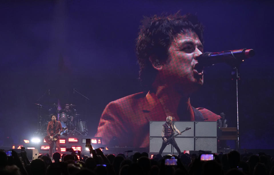 Billie Joe Armstrong of Green Day, right, is seen on a video screen as the band performs on day three of the Bud Light Super Bowl Music Fest, Saturday, Feb. 12, 2022, at Crypto.com Arena in Los Angeles. (AP Photo/Chris Pizzello)