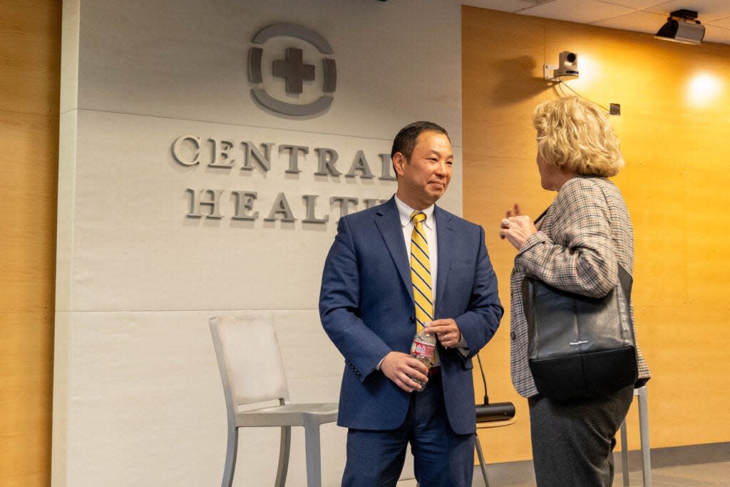 Dr. Patrick Lee talks to Central Health new board chair Ann Kitchen during a public meet and greet with candidates for the Central Health CEO position. Lee started at Central Health in January and was named in the lawsuit.