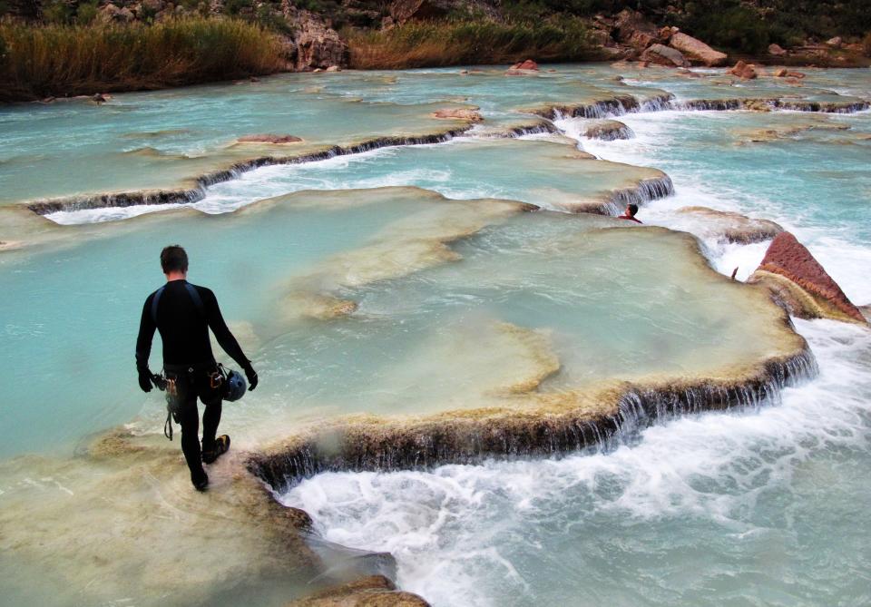 A hiker moves through the Little Colorado River on the Navajo Nation several miles upstream from the confluence with the Colorado River in Grand Canyon National Park. This part of the Little Colorado would be submerged in a 2.5 mile long reservoir from a proposed dam.